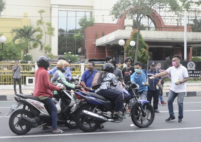 Wartawan Pokja DPRD Surabaya saat membagikan paket handsanitazer kepada masyarakat oengguna jalan, Rabu (01/04/2020)