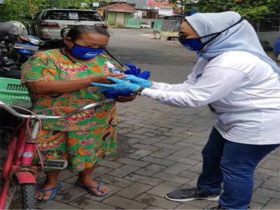 Ketua DPC Demokrat Surabaya Lucy saat memberikan bantuan berupa masker kepada warga Surabaya