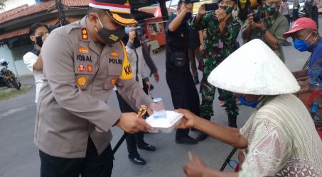 Kapolres Tegal AKBP Muhammad Iqal Simatupang Komandan Kodim 0712/Tegal Letkol Richard Arnold Yeheskei Sangari dan Komandan Satradar Tegal saat membagikan nasi kota kepada warga.