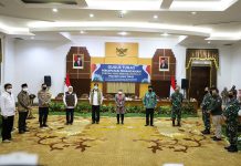 Wali Kota SUrabaya Tri Rismaharini saat menandatangani Komitmen Bersama di Pemprov Jatim