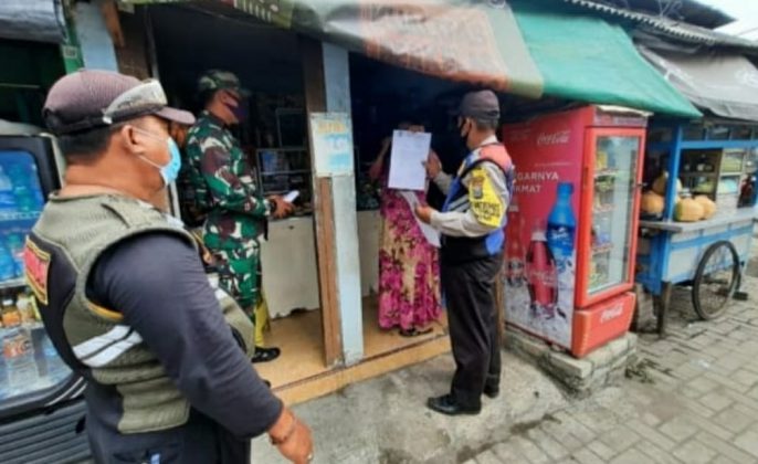Petugas dari tiga piar saat mensosialisasikan penerapan PPKM Darurat kepada warga diwilayah Surabaya Utara