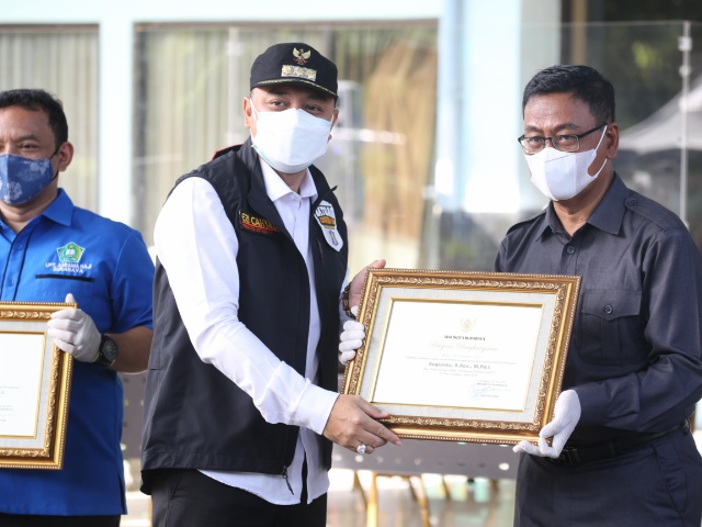 Wali kota Surabaya Eri Cahyadi saat memberikan penghargaan kepada jajaran UPT Asrama Haji Surabaya