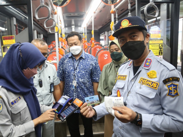 Kadishub Surabaya Irvan Wahyudrajat saat menunjukkan pembayarak melalui e-money didalam Suroboyo Bus