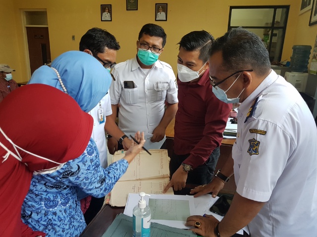 Abdul Ghoni Mukhlas Ni'am (Baju Merah) bersama Camat Tambak Sari dan lurah Pacar K3mbang serta pihak yang menyengketakan saat menyaksikan kroscek data di buku letter C milik kelurahan Pacar Kembang