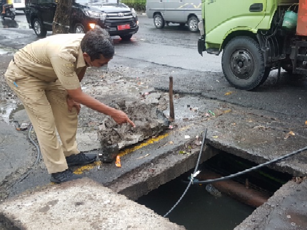 Petugas saat menunjukkan salah satu titik utilitas yang semrawut di jalan Ngagel pada Selasa (18/01/2022)