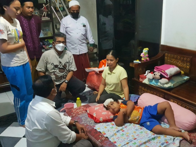 Rahardian (5) tengah dirawat ibunya Eniliana (40) saat dikunjungi Anggota DPRD Surabaya Anas Karno pada Senin 24/01/2022 malam