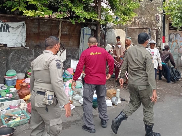 Petugas satpol PP Surabaya saat menertibkan PKL yang kembali berjuaan dipedestrian jalan Gembong Surabaya