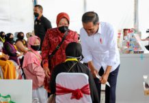 Presiden Jokowi didamping Menteri Sosial Tri Rismaharini saat menyerahkan BLT Minyak Goreng