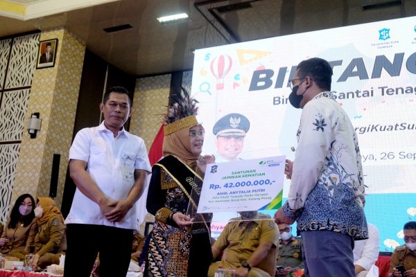 Ning Rini Indriyani ketua bunda pPAUD Kota Surabaya saat menerima santunan secara simbolis dari perwakilan BPJS Ketenagakerjaan Kota Surabaya untuk tiga buda PAUD