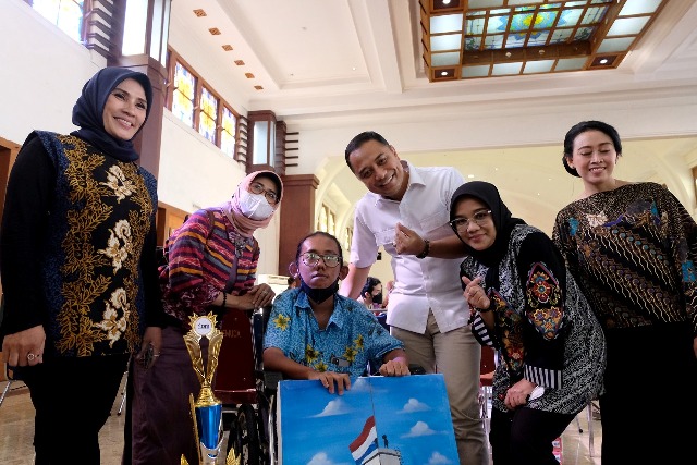 Wali Kota Surabaya bersama istri saat berfoto bersama salah satu siswa inklusi dalam sebuah pameran di Surabaya
