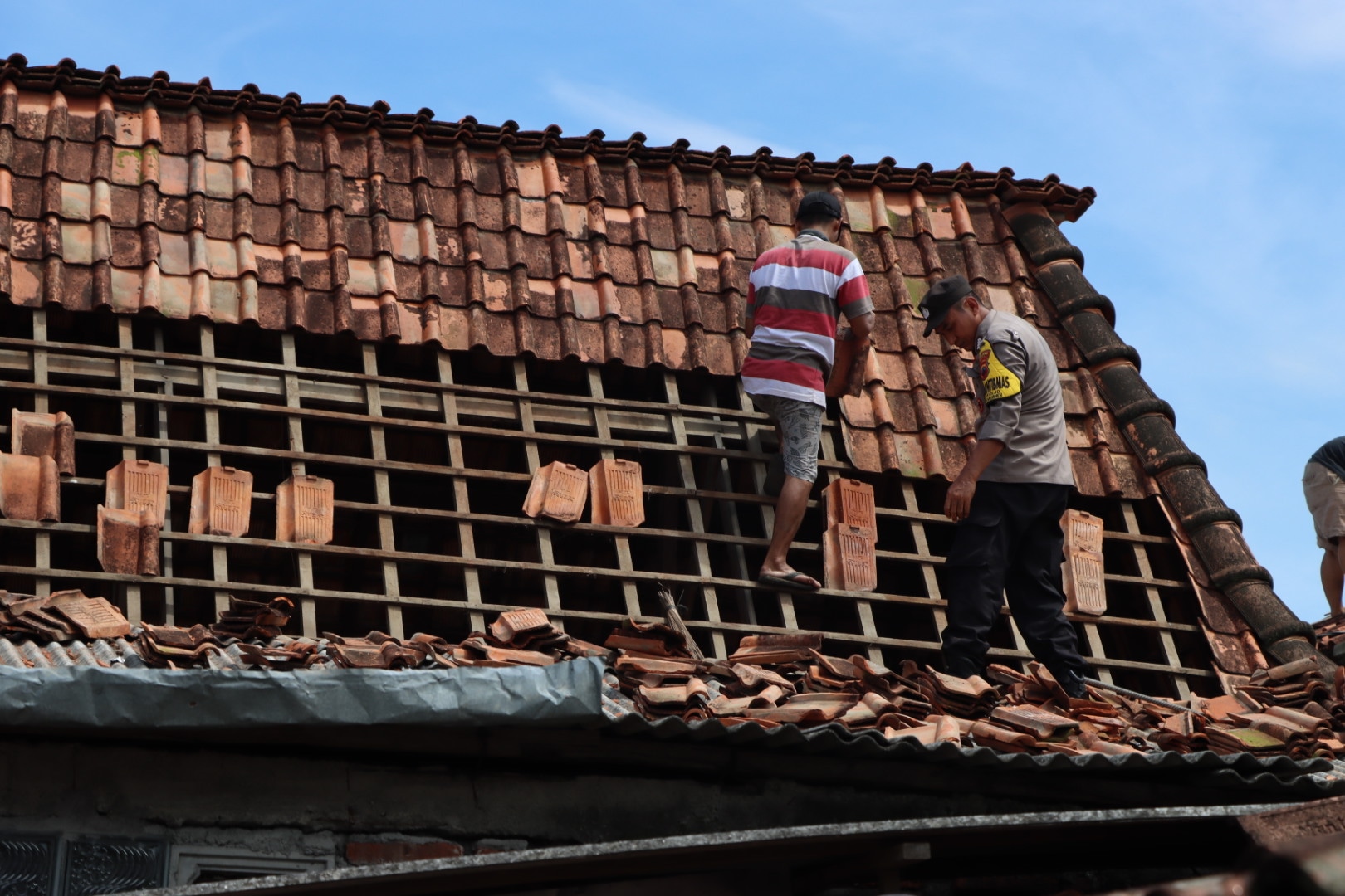 personel polres demak saat membantu memperbaiki rumah warga