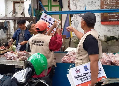 Petugas dari PDRPH Surabaya saat membagikan papan mitra kepada ppedagang daging
