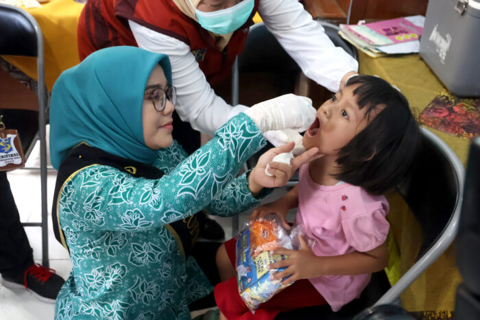 Ketua TP PKK Rini Indriyani saat memberikan imunisasi Polio kepada anak-anak di Surabaya