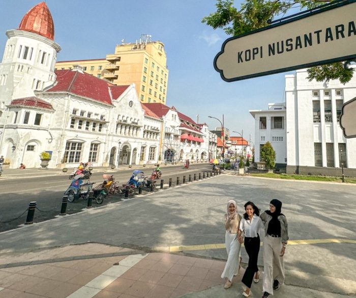 Pengunjung nampak berjalan dengan latar belakang becak terparkir dikawasan kota lama
