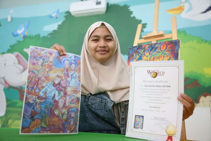 tata pelukis difabel menunjukkan karyanya yang akan dipamerkan di Paris