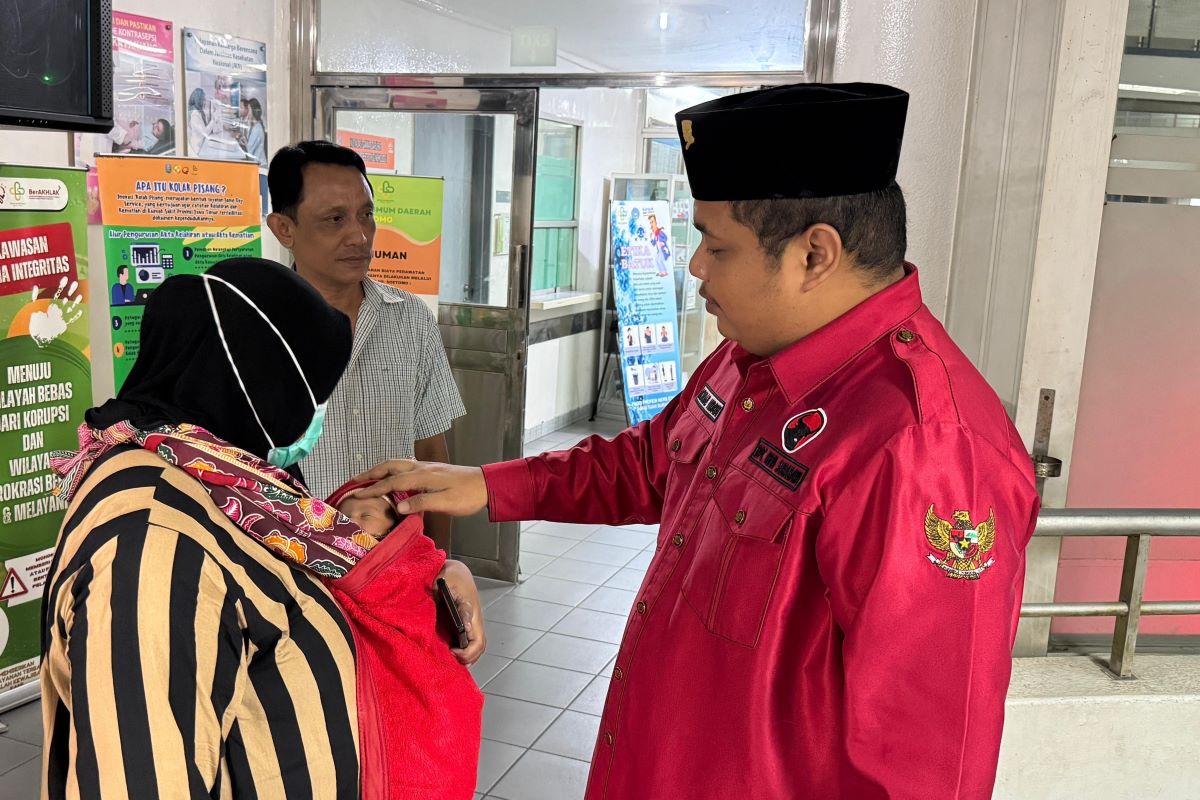 Kader PDIP Surabaya Achmad Hidayat saat menemui warga yang kesulitan membayar biaya persalaninan. foto: istimewa