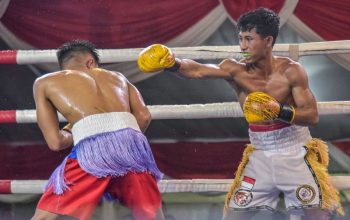 Seorang petinju tengah melayangkan pukilan kepada lawannya dalam ajang Surabaya Big Fight