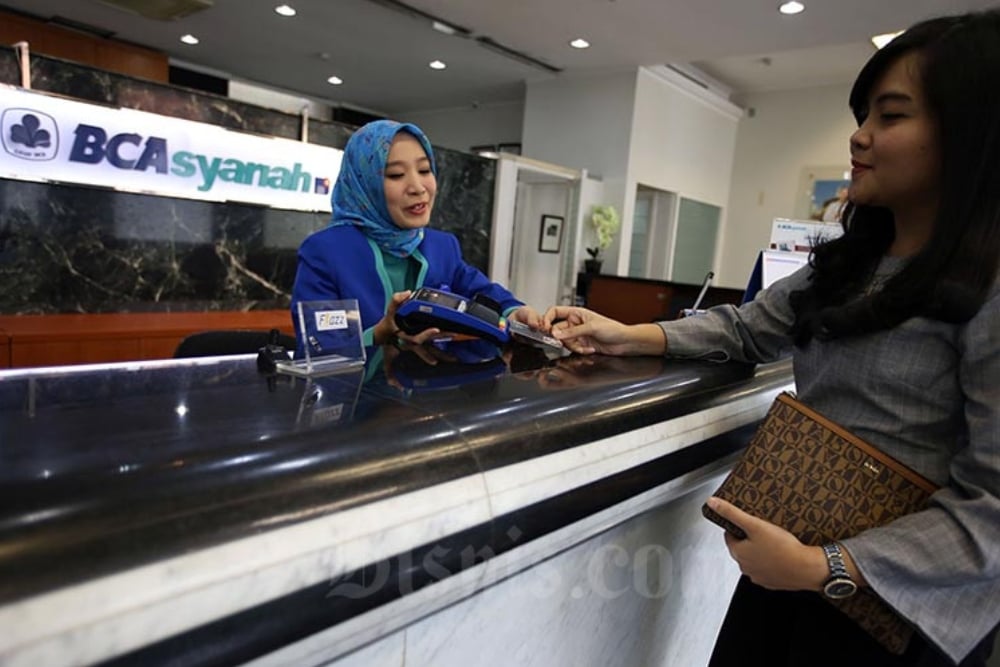 Karyawan melayani nasabah yang melakukan transaksi di kantor cabang Bank BCA Syariah di Jakarta beberapa waktu lalu. Bisnis/Abdullah Azzam