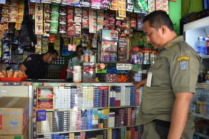 Petugas Satpol PP dan Petugas Bea Cukai Sidoarjo melakukan pemeriksaan terhadap salah satu toko kelontong di Sukolilo